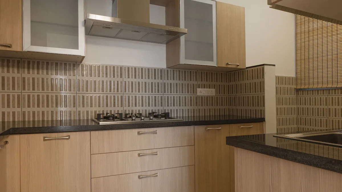 Kitchen with light timber cabinets, granite counter, gas hob and chimney hood
